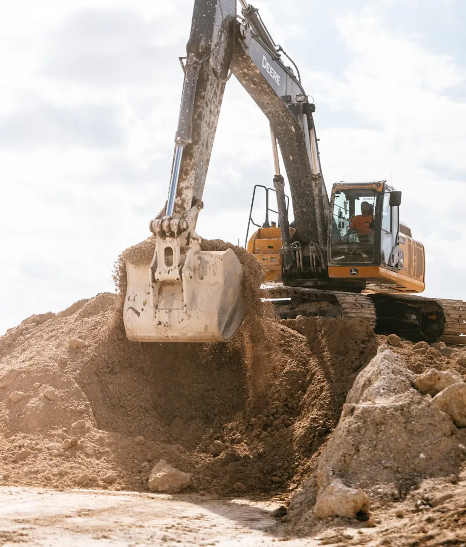 Excavator bucket lifting a load of dirt on an excavation and earthwork site